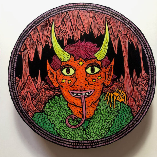 Illustration on a round wooden panel of a red skinned person with spiked yellow horns, pointy ears, a long snake like tongue and some stars on his face. He wears a fluffy green jacket, has a spider on his shoulder and is within a red cave setting.