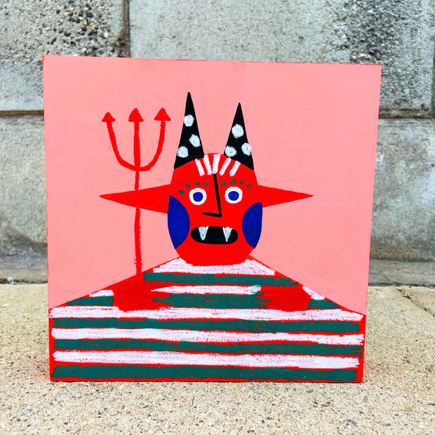 Simple drawing of a devil, with black polka dot horns on its head and red horns out the side of its head. It has 2 fangs, a pitchfork and a large green and white striped shirt. Its body is very boxy, it's visible only from the chest up.