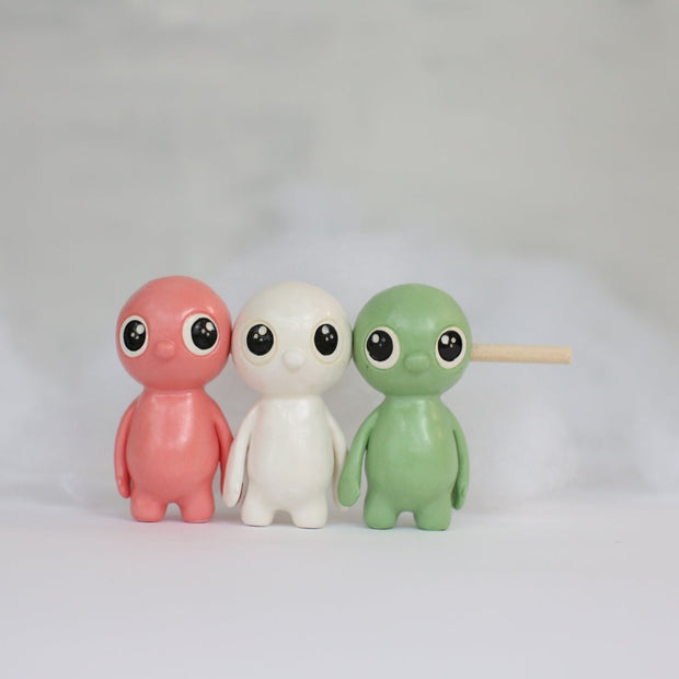 Sculpture of small characters shaped and colored to look like dango, with a stick going through their heads. They have cute eyes and a simple nose as their only facial feature.