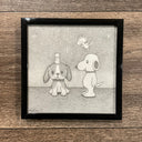 Pencil sketch of a beagle sitting with a chick sitting atop its head. Standing next to them is Snoopy, who smiles and Woodstock flies behind him. Piece is framed.