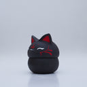 Black clay pot with a lid that looks like a fox's head, a matching black color with red ears and face paint. It has closed eyes and a small white nose. The bowl has no body details.