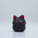 Black clay pot with a lid that looks like a fox's head, a matching black color with red ears and face paint. It has closed eyes and a small white nose. The bowl has no body details.