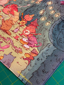 Neoprene desk mat with a colorful illustration of fantasy characters having an outdoor party with food and music, under string lights.