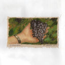 Painting on rough cut canvas of a person holding out their hand with a bunch of grapes in it.