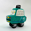 Clay sculpture of a cartoon style taxi, green in coloring with a cute smiley face.