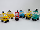 Group of clay sculptures of cartoon style taxis with cute simple smiley faces on the windshield.