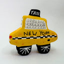 Clay sculpture of a cartoon style taxi, yellow in coloring with a cute smiley face.