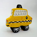 Clay sculpture of a cartoon style taxi, yellow in coloring with a cute smiley face.