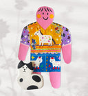 Paper cut out of a person wearing a shirt with patterning and unicorn on it. Sitting at her feet is a black and white cat.