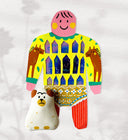 Paper cut out of a person wearing a shirt with house like patterning and horse on it. Sitting at her feet is a brown and white dog.