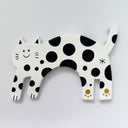 Flat clay artwork of a cat, mind jump, with a small cute cartoon smiling face. It is white with black spots.