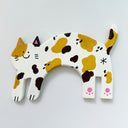 Flat clay artwork of a cat, mind jump, with a small cute cartoon smiling face. It is white with black and yellow spots.