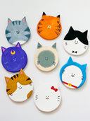 Set of colorful cat-shaped flat, round sculptures on a white background