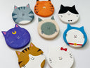 Set of colorful cat-shaped flat, round sculptures on a white background