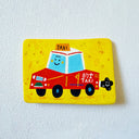A flat artwork featuring a hand-painted illustration of a smiling red taxi on a bright yellow background, photographed against a white textured wall.