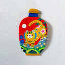 A hand-painted clay bottle-shaped wall plaque featuring a colorful tiger illustration on a red background, mounted on a textured white wall.
