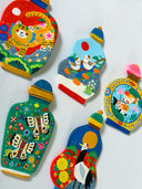 Five colorful hand-painted flat clay miniature bottles with animal and nature motifs, displayed side-by-side on a white textured wall.