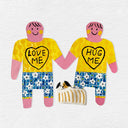 2 paper cut out dolls, wearing yellow shirts that say "Love me" and "Hug Me" and holding hands. A small clay dog sits in between them.
