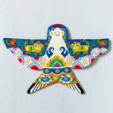 A colorful hand-painted clay bird wall hanging with intricate folk-art patterns, displayed on a textured white wall.