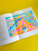 Open book with a colorful illustration of a character with a lava-like effect on a yellow background