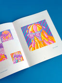 Open book displaying colorful abstract art on a blue background