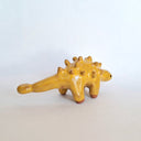 Yellow ceramic dinosaur figurine on a white background