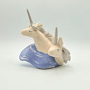 Ceramic sculpture of 2 unicorn busts, white and speckled. They emerge from a wave shape base.