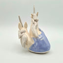 Ceramic sculpture of 2 unicorn busts, white and speckled. They emerge from a wave shape base.