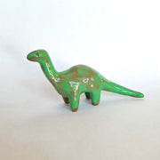 Green dinosaur figurine on a white background