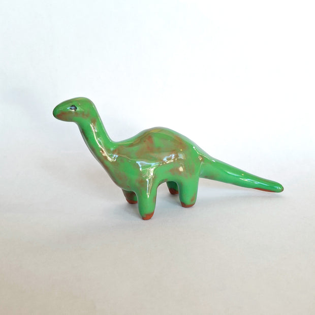 Green dinosaur figurine on a white background