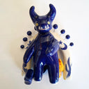 Blue ceramic wall sculpture with decorative elements on a white background