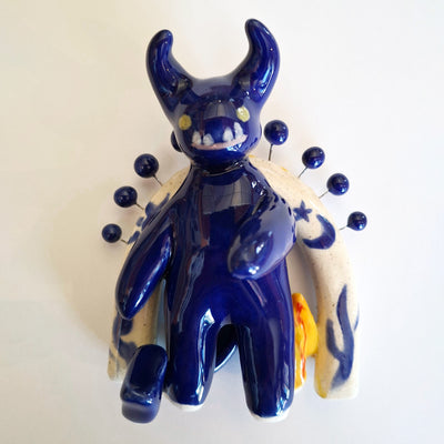 Blue ceramic wall sculpture with decorative elements on a white background