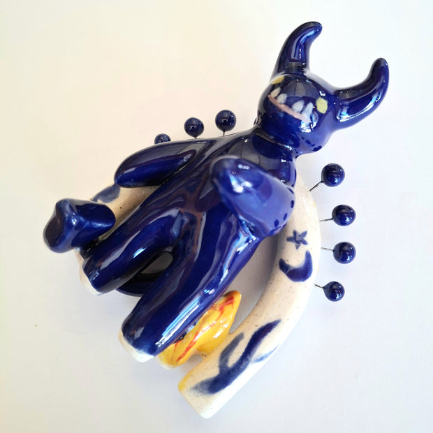 Blue ceramic oni sculpture on a white background