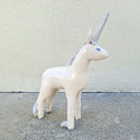 Unicorn ceramic figurine on a concrete surface with a light gray background