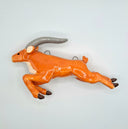 Glazed ceramic sculpture of an orange elk character, bounding forward with long front legs and short back legs. They have long gray horns.
