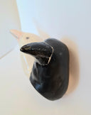 Two ceramic crow figures, heads only, both growing out of the same neck - one beige and one black, on a light background