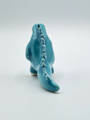 Blue ceramic kaiju figurine on a white background