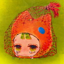 Painting of a face with crying green eyes, wearing an orange colored cap that is shaped like a cat. The head is within a red mesh bag, most commonly used for produce.