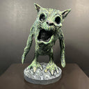 Green alien-like creature figurine on a dark background