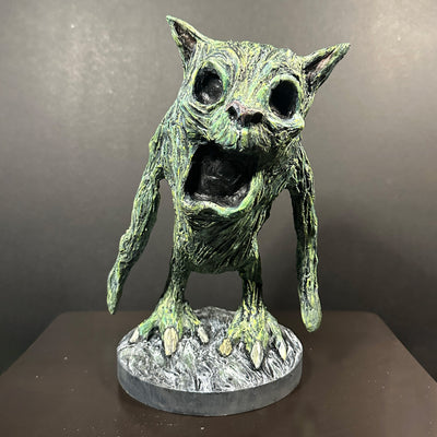 Green alien-like creature figurine on a dark background
