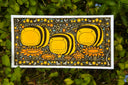 Illustration of 3 very chubby stylized bees, on a patterned floral background with a matching floral border. Piece is against greenery.