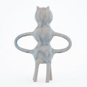 Ceramic sculpture of a character with a body made of 3 spheres stacked atop one another. Its arms are like mug handles.