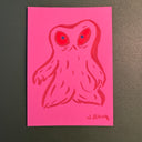 Marker illustration on neon pink paper of a blob monster with 2 red eyes.