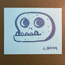 Marker illustration on blue colored paper of a cartoon skull with an underbite.