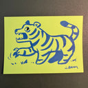 Blue marker illustration on neon yellow paper of a tiger.