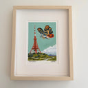 Framed artwork of a moth kaiju and Tokyo Tower on a light gray background
