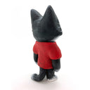 Sculpture of a black and white cat, standing on 2 legs like a person and wearing a red shirt that reads "The Specials." 