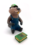Sculpture of a beaver, dressed like a person in overalls and a green hat. It sits and holds Henry David Thoreau's "Walden"