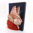 3D sculpture of the profile view of an orange cat, wearing a red hoody. It is attached to a flat dark blue wood panel.