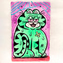 A colorful cartoon-style art print of a green cat with pink eyes and a bandage on its chest, set against a pink background with blue lightning-like lines and small hearts. The artist's signature 'SCALZO' is visible at the bottom.